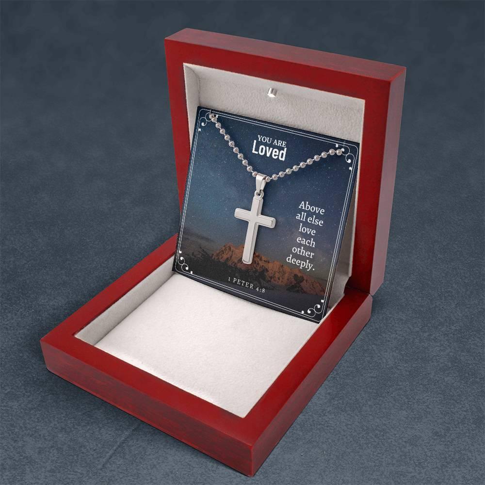 Angled view of 1 Peter 4:8 Faith Cross Necklace in premium red box, featuring stainless steel cross and heartfelt scripture message.