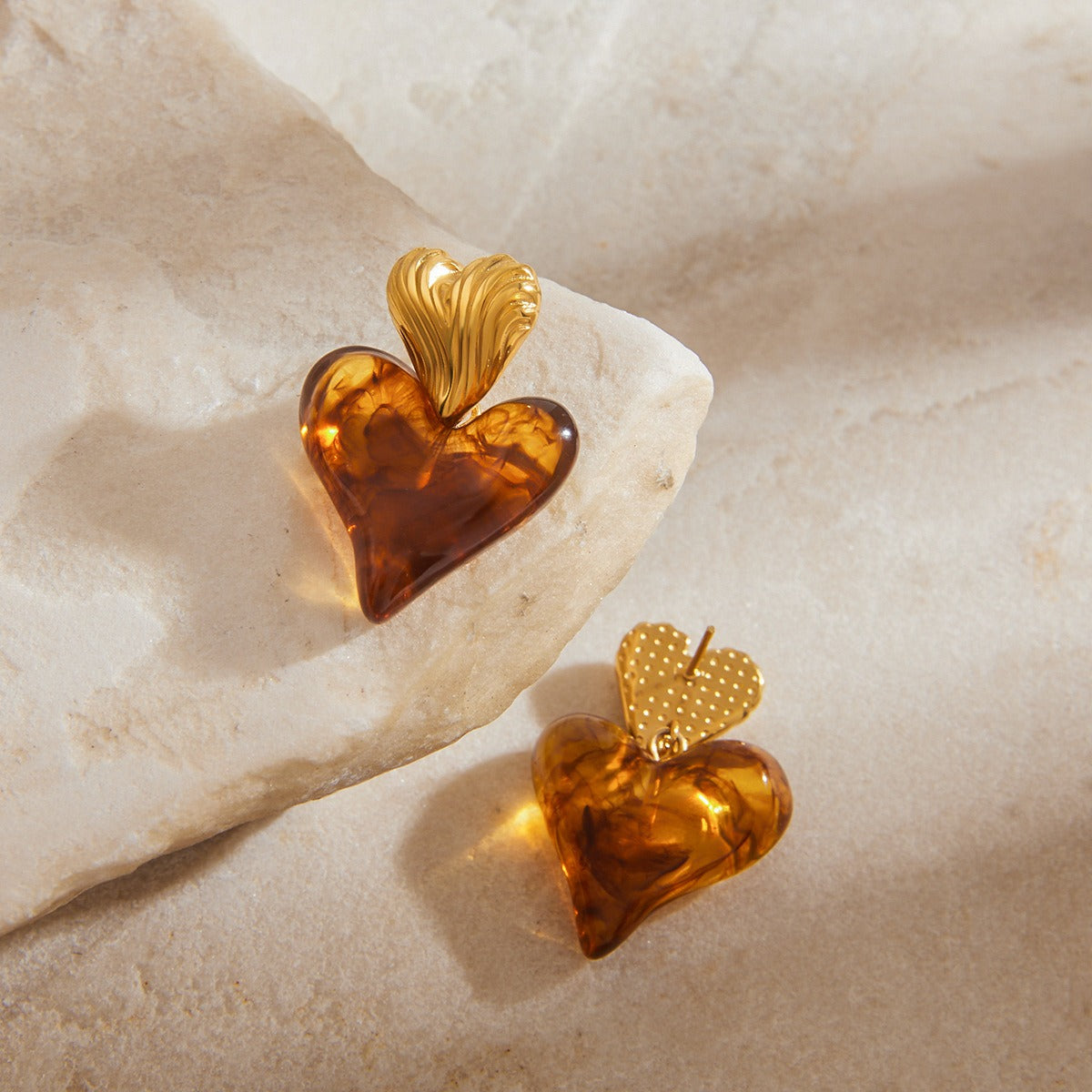 Close-up of 18K gold heart stud earrings showing elegant design detail
