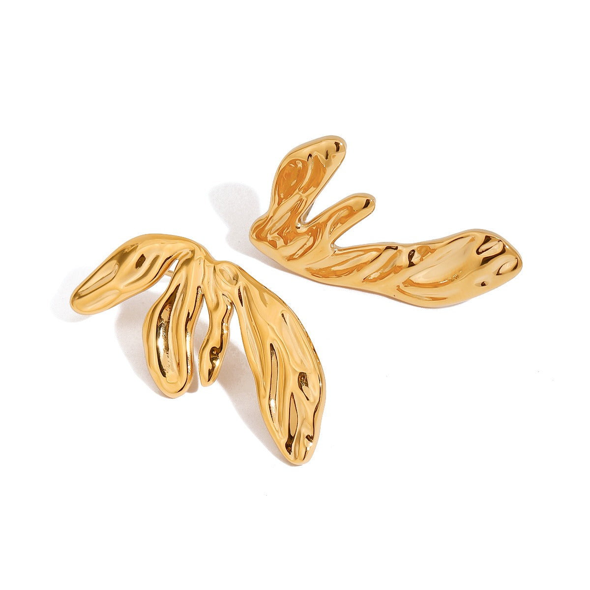 Close-up of 18K gold wing earrings showing geometric design detail
