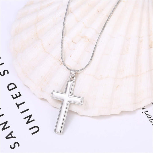 Silver cross necklace on a shell with 'Sanitized' text in the background