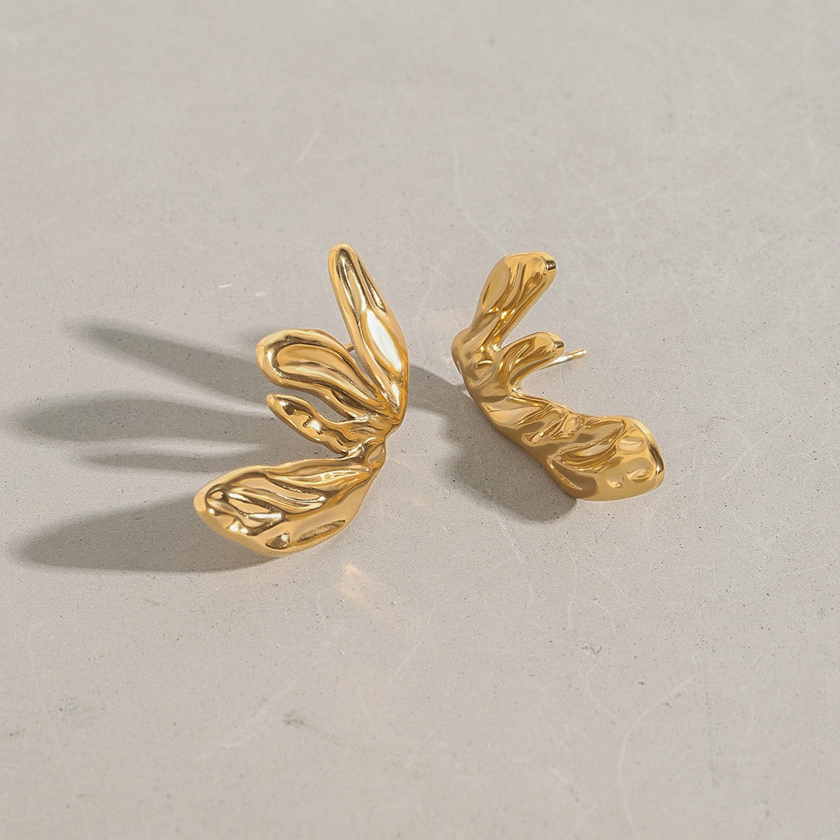 18K gold wing earring detail showing modern geometric design
