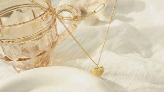 18K gold heart and star necklace flat lay - double layer design close up vidéo